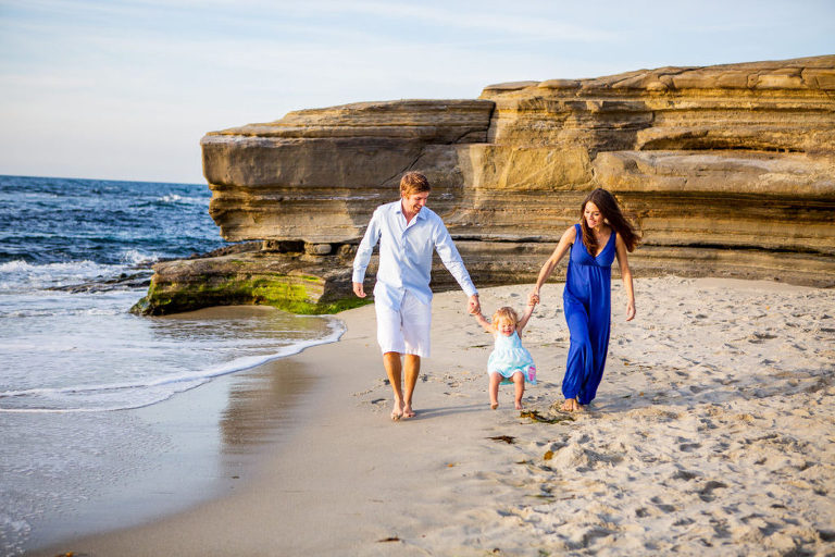 family of 3 walking on the beach
