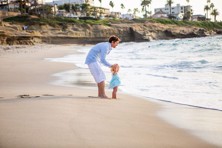 father and daughter at the beach shoreline