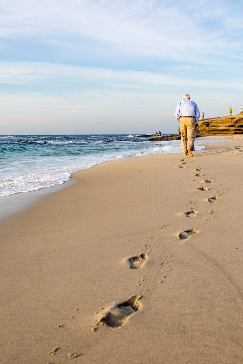 grandfather walking away on beach