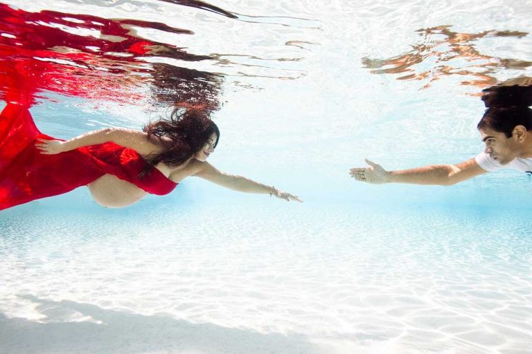 husband and wife underwater maternity photos