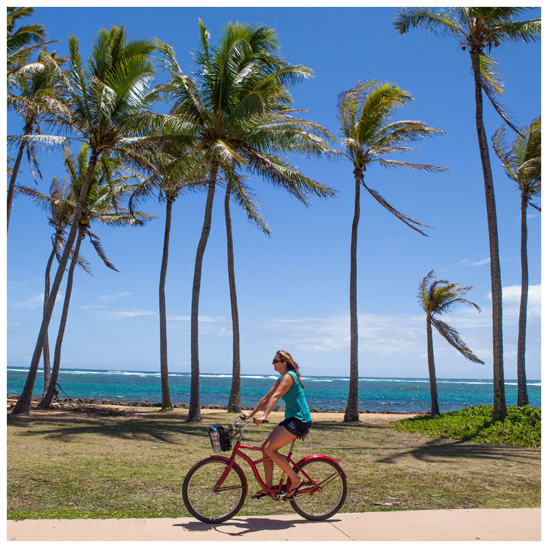 girl riding a bike under the palm trees